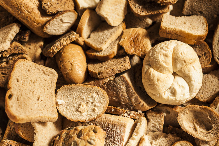 A pile of bread and baked goods with mould growing on them